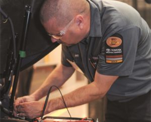 Toyota technician under hood